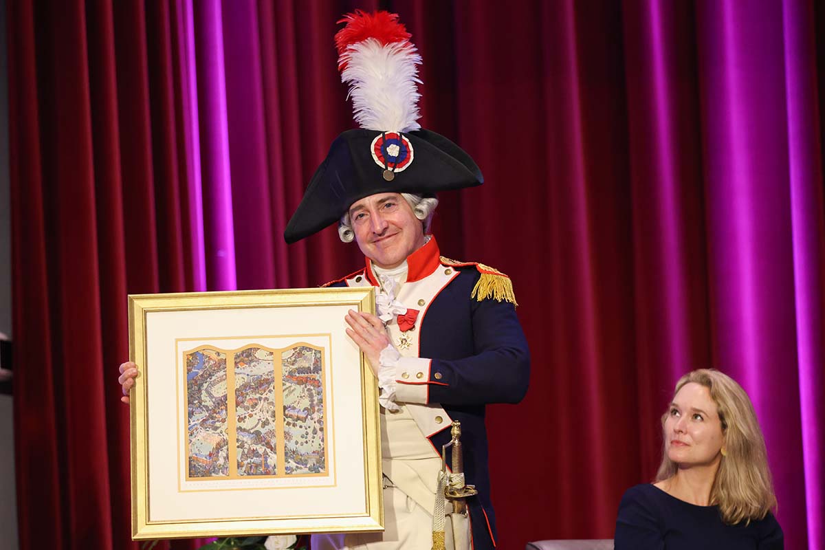 Marquis impersonator holds a framed triptych