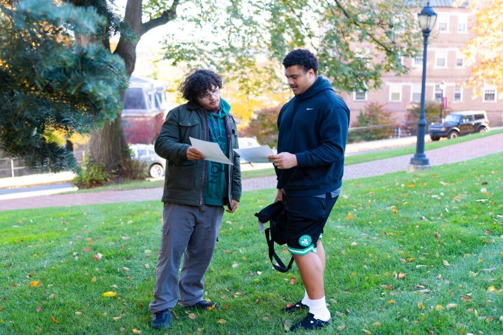 Jesse Kronenfeld Casis ’29 (left) and Sean Kabengele ’29 discuss their rephotography ideas as they survey the campus. | Photo by JaQuan Alston