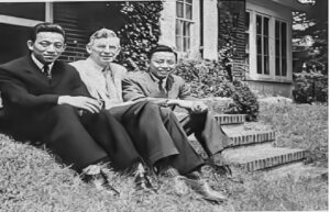 Dieu, (far right) is pictured with Dean Hunt (middle) on the lawn of the Dean's home.
