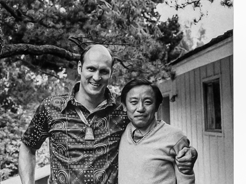 Dieu, right, is pictured with classmate Don Sayenga '56 at Camp Pendleton. Don has his arm around Dieu and they are smiling at the camera.