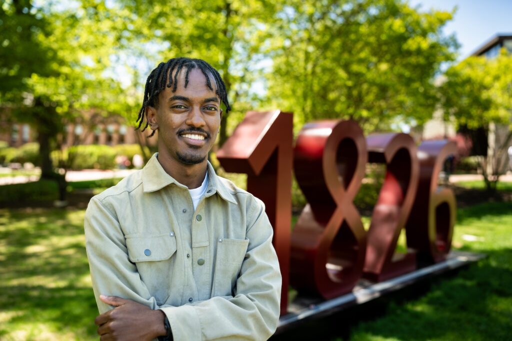 Abdi Kusata is pictured in front of the 1826 sign on the Quad