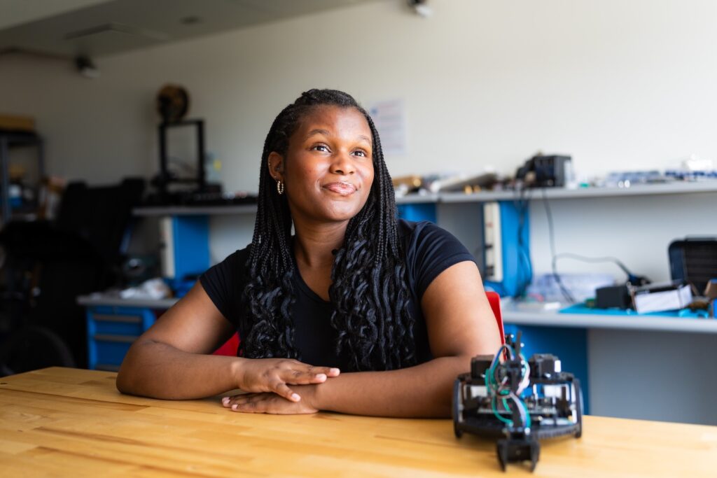 Paris Francis sits at a table with a mechanical piece in front of her