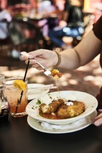 Diners dig into a bowl of aranciata in sauce.