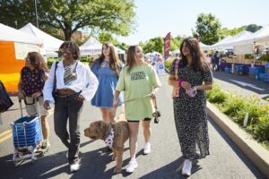 Four students walk through the outdoor Easton Farmers' Market.