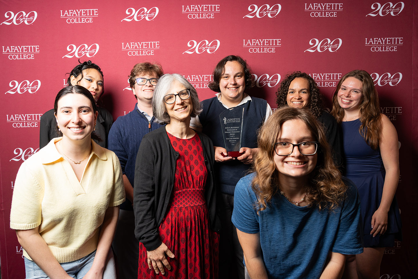 A group of faculty and staff stand together and are smiling at the camera.