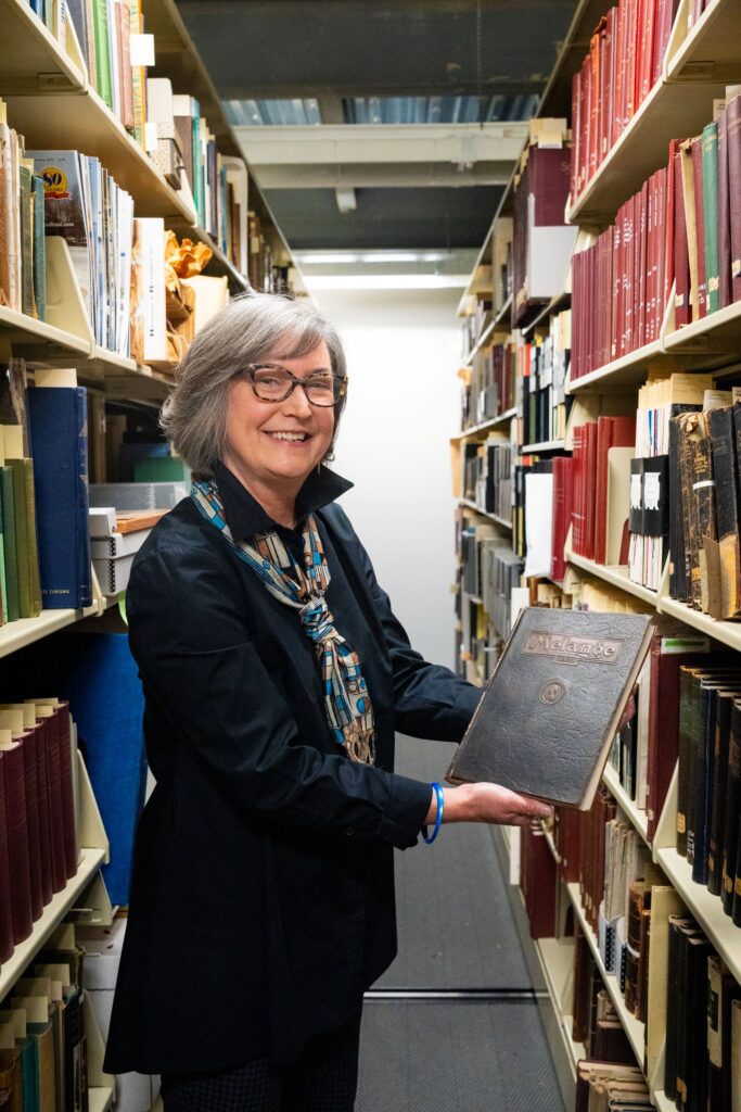 "A treasure on our shelves,” says Elaine Stomber, co-director of Special Collections and College Archives and College Archivist, carefully handling a 1921 Mélange.