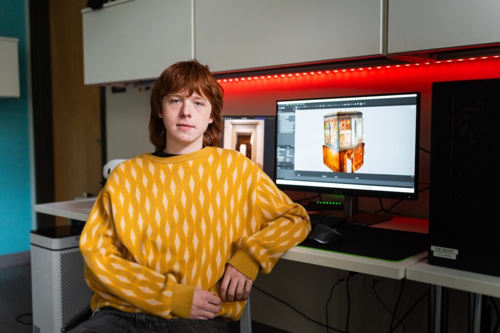Max O'Rourke sits in front of a computer screen with a 3D design on it.