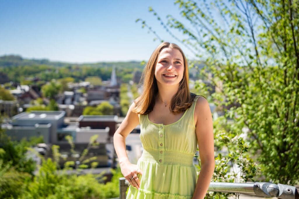 Molly Dormer stands outside on campus with a view of Easton in the background