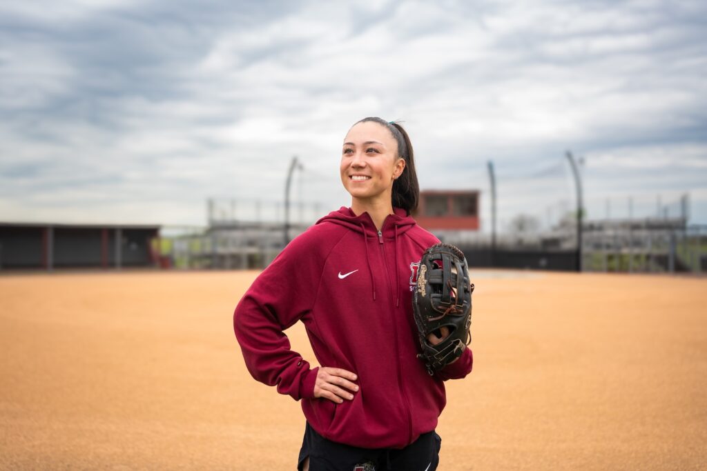 Olivia Catalina stands on the softball field with her glove in hand.