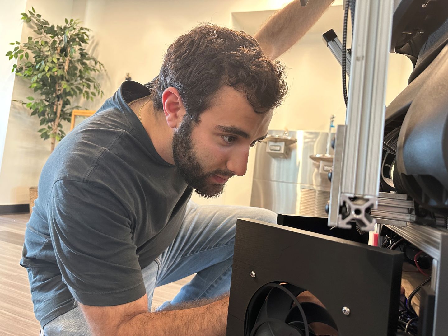 Jaden Wurm ’26 makes a few adjustments on the autonomous tour guide before its debut. | Contributed photo