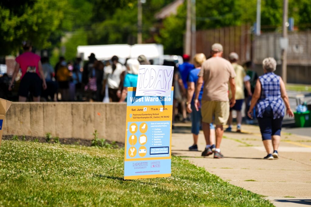 Community members gather by Paxinosa Elementary for the West Ward Sale. A sign advertises the sale