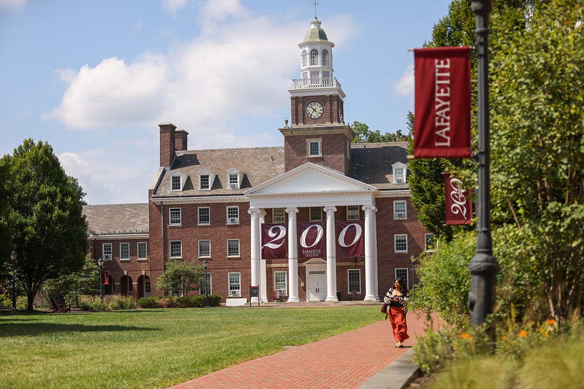 A person walks in front of Watson Hall