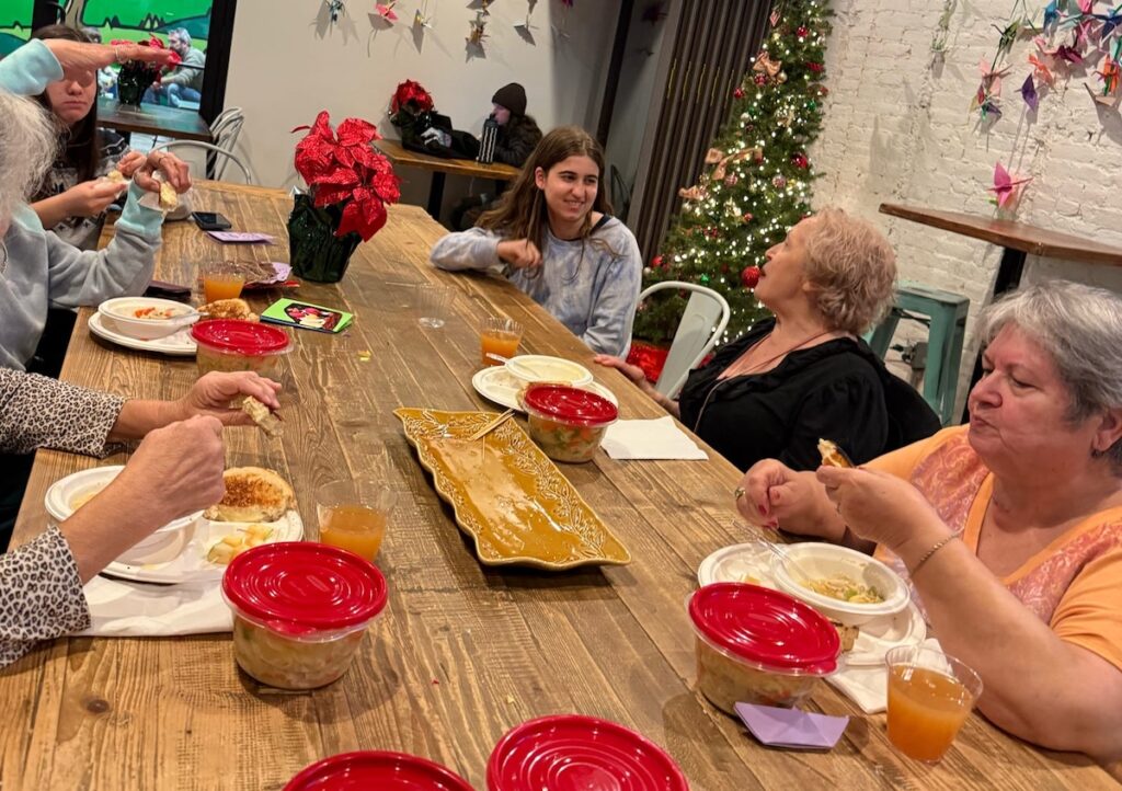 Lafayette students talk with participants of the Meals at the Market program as they enjoy a meal in the Community Room at Easton Public Market.