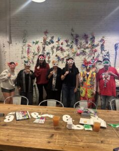 Landis volunteers and Easton community members stand together in the community Room displaying masks they crafted during Meals at the Market.