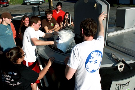 Students load one of the College’s Earth Tub composting units.