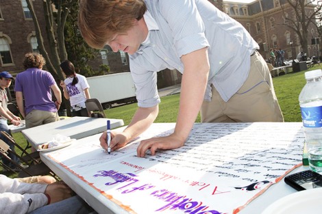 Ray Van Cleve '11 signs the poster entitled 