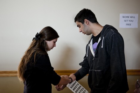 Jenny Schechner '12 simulates the processing of a detainee by putting a number tattoo on his arm.