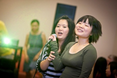 Zili Wang '15, left, and Anni Gao '15 sing song lyrics from Chinese characters projected on a wall.
