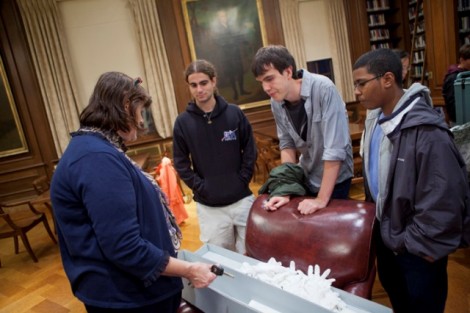 In Kirby Library, the final stop on the scavenger hunt, Diane Shaw, special collections librarian and College archivist, shows the sword to Daniel Robitzsk '15, left, David Bedding '15, and Andy Polanco '15.