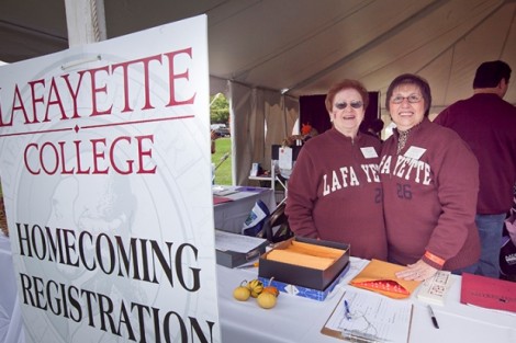 Ruth Trincheria, left, office assistant in alumni affairs, and Ruth Hutnik, office coordinator in alumni affairs, greet alumni at the registration tent.