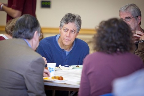 Gary Gordon, professor of mathematics, speaks with others at his table.