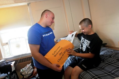 Zach Leff '16 shows his little brother, Kyle, some information inside his orientation packet in his dorm in Ruef Hall.
