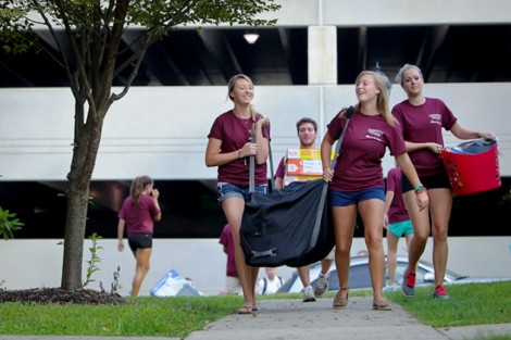 Members of Alpha Phi sorority help carry items into Kamine Hall.