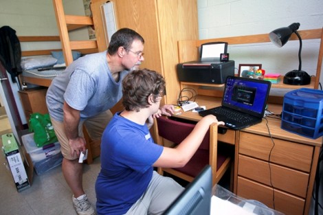 Kevin Strickland, left, helps his son, Brandon '16, set up his computer in Conway House.