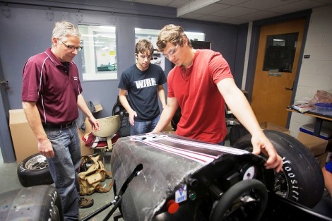 Scott Hummel, professor of mechanical engineering (l-r), Nicholas Moneta '12, and Shane Chalupa ’12 put on the hood of the car.