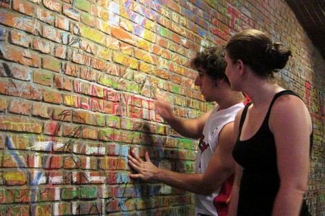 Kelsey Theriault '13 and James Kugel '13 write “Lafayette” on the wall of a popular pizza restaurant, Tube Station Bistro, in Beijing.