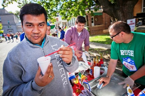 Hermendra Bhola '12 enjoys a raspados (a shaved ice cone with flavoring and cream) at the Hispanic Society of Lafayette table. 