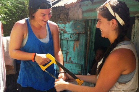 Sarah Nusbaum '13, right, anxiously watches as Jess Rothstein '13 saws a two-inch PVC pipe that Sarah held in her hands.