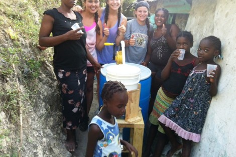 The team joins some of the community members in the first drink of filtered water.