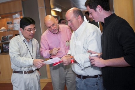 Yih-Choung Yu, l-r, associate professor of electrical and computer engineering, and John Greco, professor of electrical and computer engineering, go over the day’s schedule with a family.