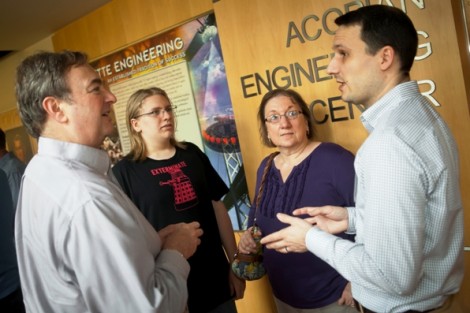 Josh Smith, right, assistant professor of mechanical engineering, speaks with a family.