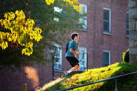A student bounds up some steps alongside South College.