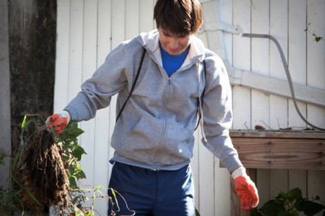 Aleksey Zebrowski '16 helps to clean up Easton’s Weed and Seed Sunflower Garden. 