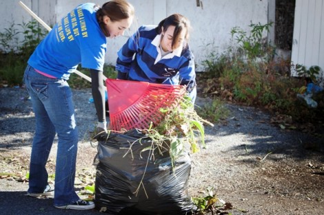 Kelly Carpency '16, left, and Dena Inqui '13 throw some weeds out at Easton’s Weed and Seed Sunflower Garden.