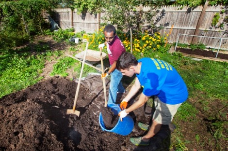Students shovel mulch at the West Ward Neighborhood Partnership's Lynn Street Garden.