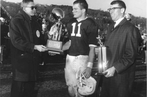 Lafayette quarterback George Hossenlopp ’65, center, receives the trophy for being named the outstanding player in the 100th Lafayette-Lehigh game in 1964 from John B. Hench ’65, president of the Lafayette Student Council. At right is Rodger Digilio, president of the Lehigh Student Council.