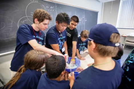 Matt Muller '14, left, and Henry Lam '14 teach elementary students how to make slime during the STEM Camp. 