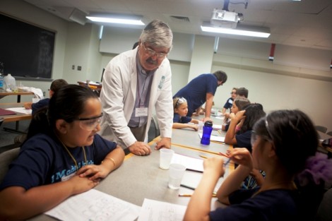 Javad Tavakoli, professor of chemical and biomolecular engineering, shows campers how to dissolve different substances in water.