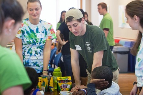 Evan Gooberman '13 helps a student with a craft.