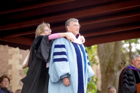 Nancy Kuenstner ’75 presents Joseph Cox ’68 with the hood emblematic of his honorary Doctor of Humanities degree.