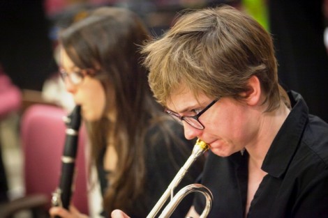 A female student plays clarinet and another plays the trumpet.