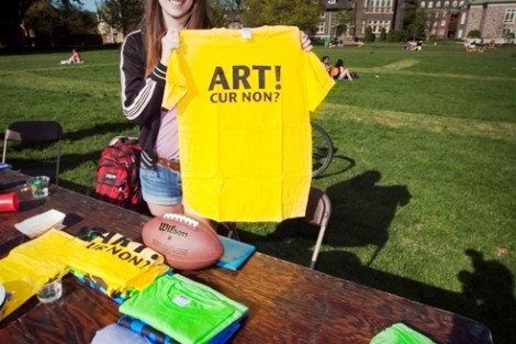 Brenna Murphy ’14 holds up a T-shirt at the Arts Society table.