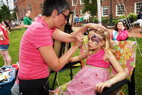 A future Leopard gets her face painted at the kids’ tent in Anderson Courtyard.