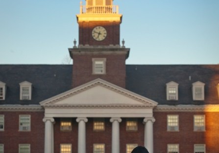 Rijan Maharjan '14 sits in Anderson Courtyard as the sun rises over Watson Hall.
