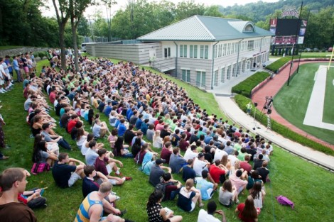 The first-year students sit on the grass hill of Fisher Stadium for the class photo.