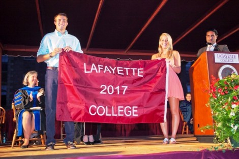Christopher Sutka ’17, the son of Michael '83 and Tracy  Hagert Sutka ’82, and Carly Loveman '17, daughter of Sally Oaks Lovemen ’84 and granddaughter of Wilber Oaks ’51, accept the Class of 2017 banner. 